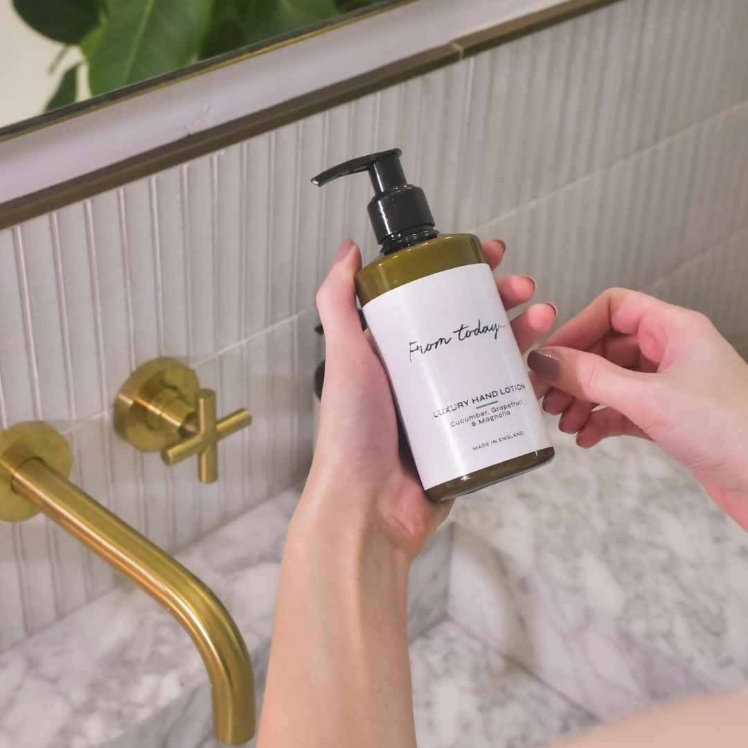 luxury hand lotion gift in cucumber, grapefruit & magnolia being used by woman in bathroom