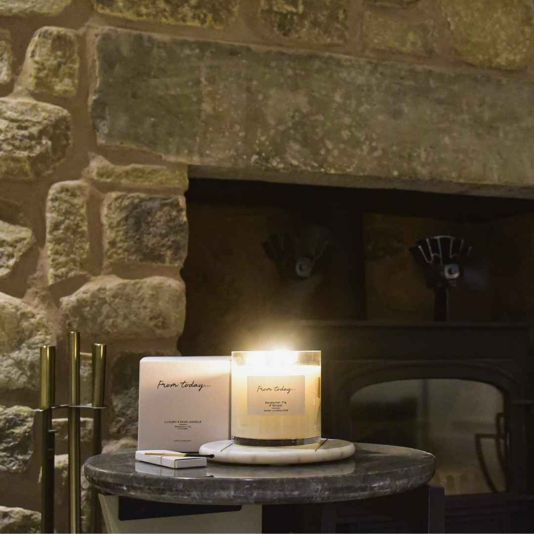bergamot, fig & ginger 3 wick luxury scented candle in a home setting in front of fire place